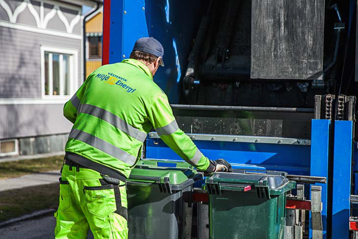 Sopåkare som står bakom en sopbil